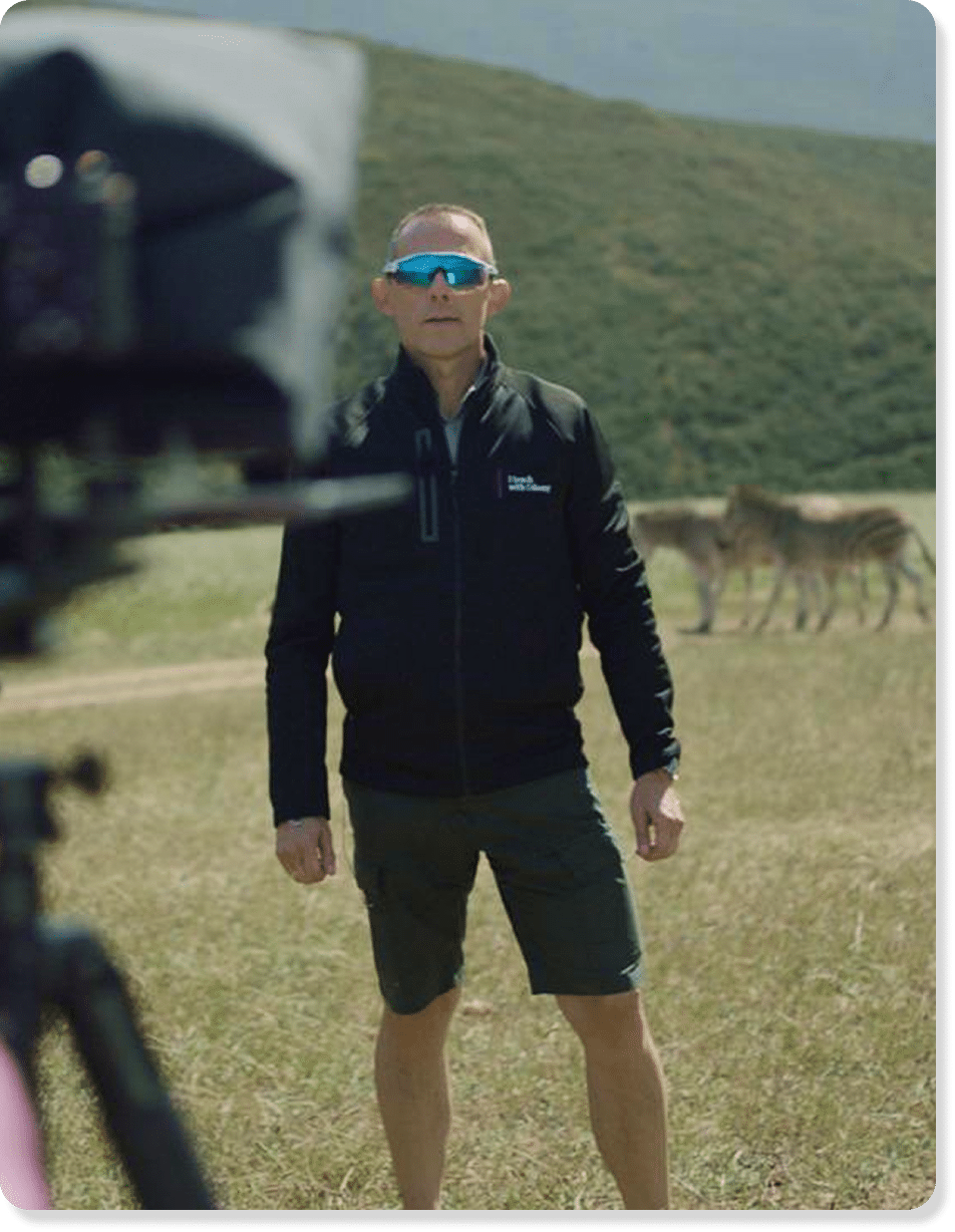 Axel Rittershaus vor Kamera mit Zebras im HG